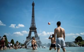 Teenagers play volleyball in the Trocadero fountain as France swelters in a heatwave.