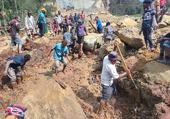 This handout photo taken and received on May 26, 2024 from the International Organization for Migration shows people digging at the site of a landslide at Yambali Village in the region of Maip Mulitaka, in Papua New Guinea's Enga Province. More than 670 people are believed dead after a massive landslide in Papua New Guinea, a UN official told AFP on May 26 as aid workers and villagers braved perilous conditions in their desperate search for survivors. (Photo by Mohamud Omer / International Organization for Migration / AFP) / RESTRICTED TO EDITORIAL USE - MANDATORY CREDIT "AFP PHOTO / INTERNATIONAL ORGANIZATION FOR MIGRATION / MOHAMUD OMER - NO MARKETING NO ADVERTISING CAMPAIGNS - DISTRIBUTED AS A SERVICE TO CLIENTS - NO ARCHIVE