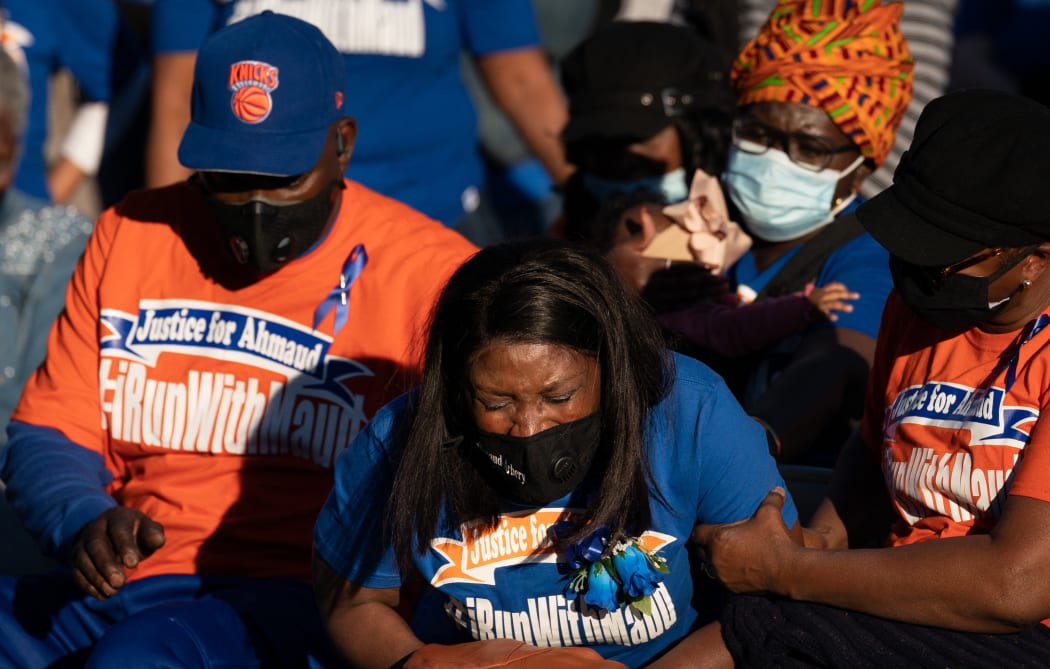 WAYNESBORO, GA - FEBRUARY 23: Wanda Cooper-Jones, mother of Ahmaud Arbery, center, is comforted by her brother, Inus Holmes, left, and family during a vigil for Ahmaud at New Springfield Baptist Church on February 23, 2021 in Waynesboro, Georgia. A