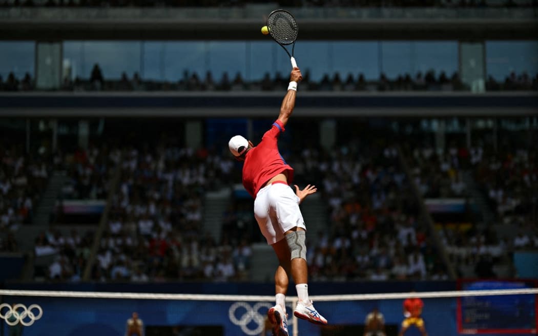 Serbia's Novak Djokovic serves to Spain's Carlos Alcaraz during their men's singles final tennis match on Court Philippe-Chatrier at the Roland-Garros Stadium during the Paris 2024 Olympic Games, in Paris on August 4, 2024. (Photo by PATRICIA DE MELO MOREIRA / AFP)