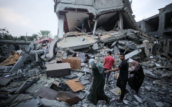 Palestinians gather at the site of Israeli strikes on houses in Deir Balah in the central Gaza Strip, on October 24, 2023, during ongoing battles between Israel and the Palestinian Hamas group.