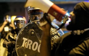 Troopers in riot gear watch as demonstrators gather outside Akron City Hall to protest the killing of Jayland Walker, shot by police, in Akron, Ohio, July 3, 2022.