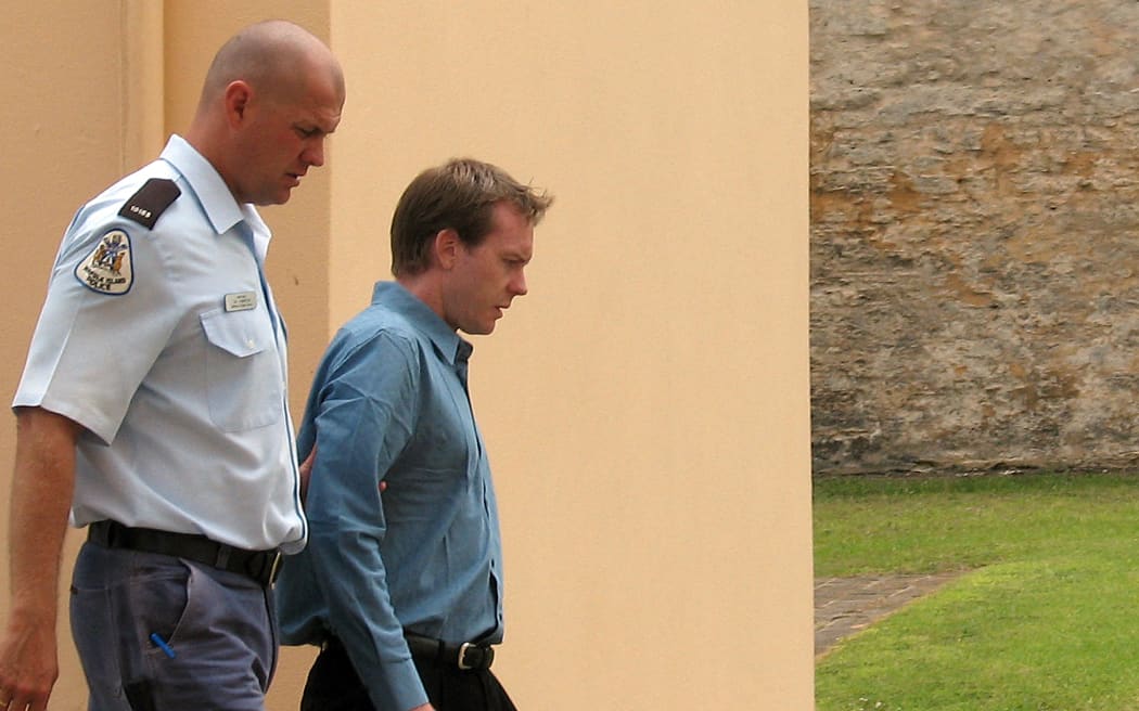 New Zealander Glenn McNeill (R), age 29, is led from the cells to the courtroom in the 175-year-old former military barracks in Kingston in the Australian territory of Norfolk Island, 02 February 2007, where he faces a charge of murdering Australian woman Janelle Patton on March 31, 2002.  It is the first murder trial on the island in 150 years since it was settled by the descendants of the British sailors involved in the famous 'Mutiny on the Bounty'.  AFP PHOTO/Lawrence BARTLETT (Photo by LAWRENCE BARTLETT / AFP)