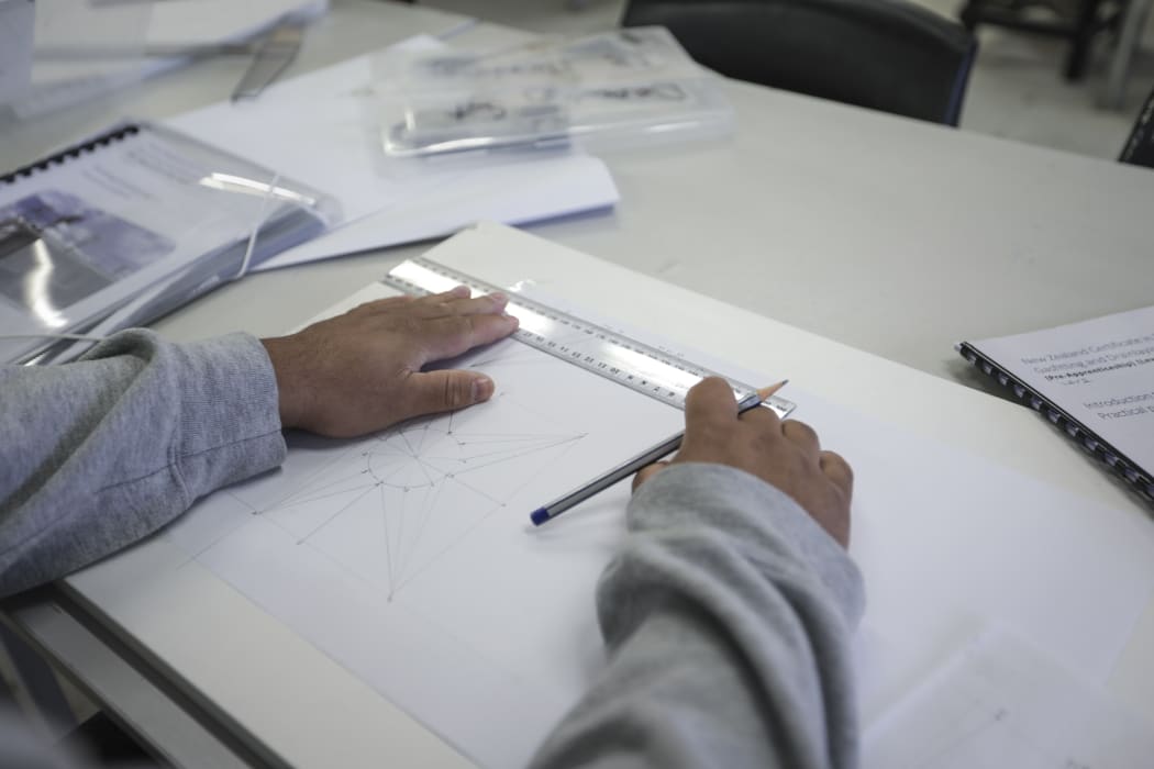 An inmate at Rimutaka Prison. The first house being built by carpentry students at the prison has been completed, a crane lifted the building over the wire so it can be transferred to a permanent site.