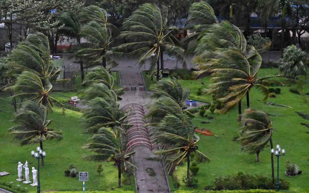 Palm trees sway as strong winds arrive ahead of the landfall of Typhoon Kalmaegi near Quy Nhon beach in Gia Lai province in central Vietnam on November 6, 2025. Typhoon Kalmaegi's windspeeds were increasing November 6 as it headed towards Vietnam, where fear was mounting the typhoon could compound the damage of a week of flooding that has already claimed 47 lives. (Photo by NHAC NGUYEN / AFP)