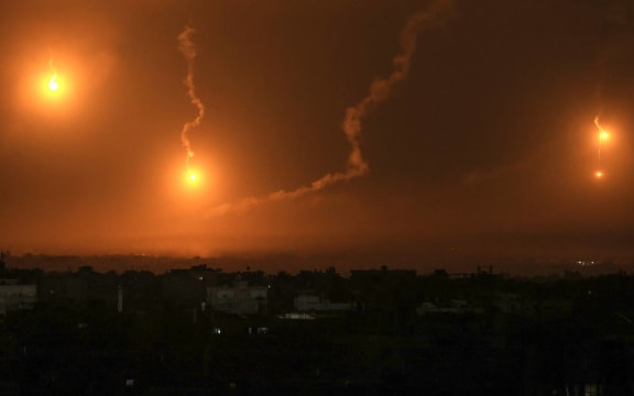 Israeli flares light the sky above Khan Yunis in the southern Gaza Strip, on December 1, 2023, as fighting resumed after the expiration of a seven-day truce between Israel and Hamas militants. A temporary truce between Israel and Hamas expired on December 1, with the Israeli army saying combat operations had resumed, accusing Hamas of violating the operational pause. (Photo by SAID KHATIB / AFP)