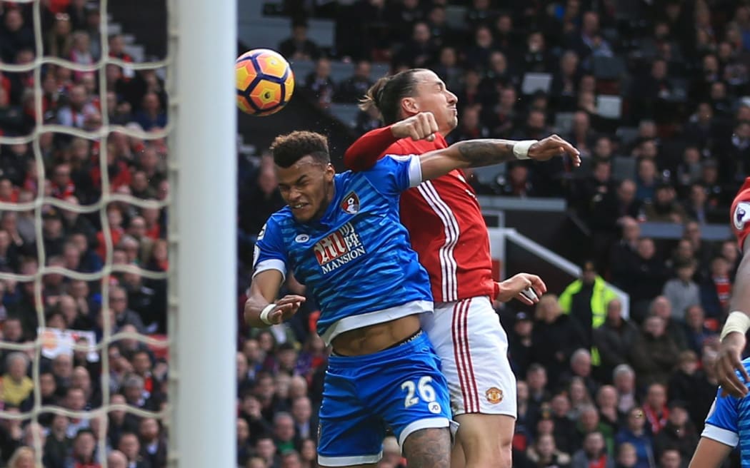 Zlatan Ibrahimovic of Manchester United and Tyrone Mings of Bournemouth clash.
