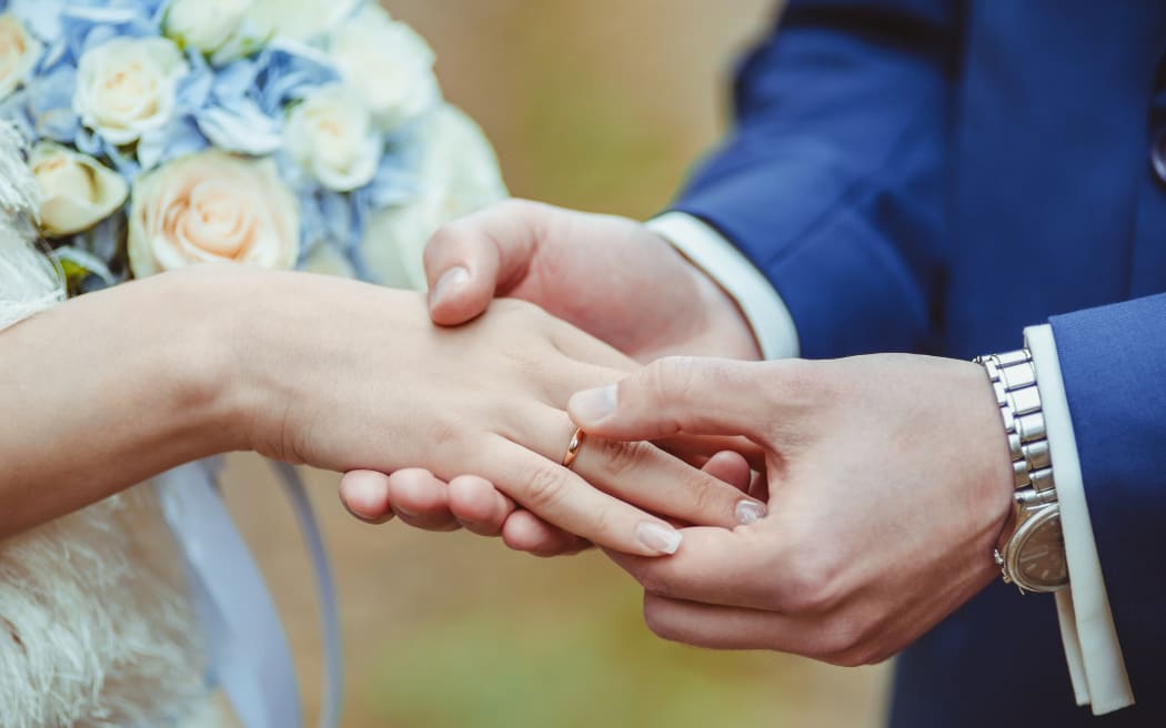 Groom's putting a wedding ring on the bride's finger