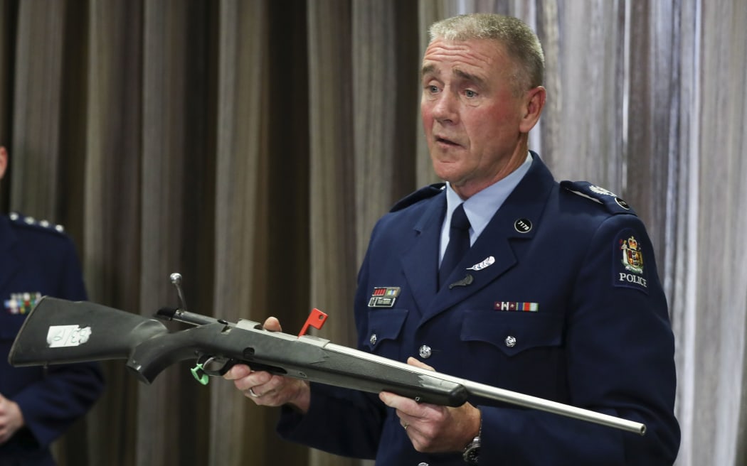 Senior Sergeant Paddy Hannon shows media a bolt-action rifle that will remain legal, providing the magazine takes only 10 rounds or less.