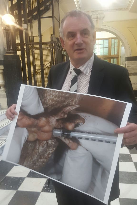 Trevor Mallard with a picture of an infected possum