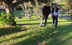Denis Snelgrove, left, with Allan Dodson who runs the Porirua War Stories site, at the unmarked grave at the cemetery on Kenepuru Drive, Porirua, where his great uncle Willie Snelgrove is buried.