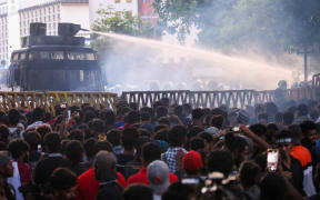 Police use a water canon to disperse demonstrators taking part in an anti-government protest demanding the resignation of Sri Lanka's President Gotabaya Rajapaksa over the country's crippling economic crisis, in Colombo on July 8, 2022. (Photo by AFP)