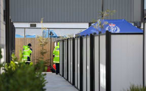 Police set up a blue specialist search group tent in the front yard of a Christchurch apartment as they investigate the disappearance of Ping Lyu, 41, who was last seen on Saturday.