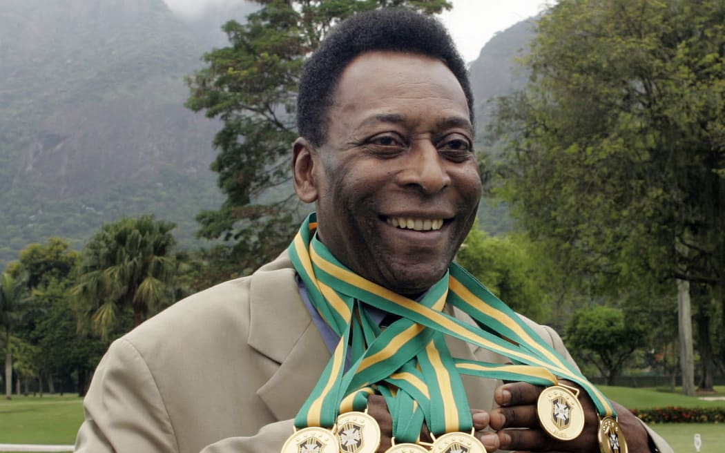 Brazilian football legend Edson Arantes do Nascimento, known as 'Pele', poses with his six Brazil's champion medals during a ceremony in Rio de Janeiro, Brazil in 2010. He has died aged 82.