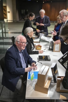 Ian F Grant signing copies of Pressing On at the National Library launch.