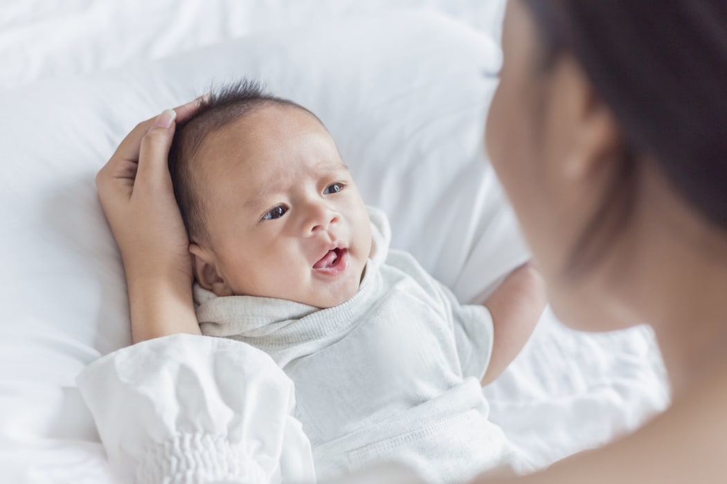 Mother hand holding and playing with newborn baby,