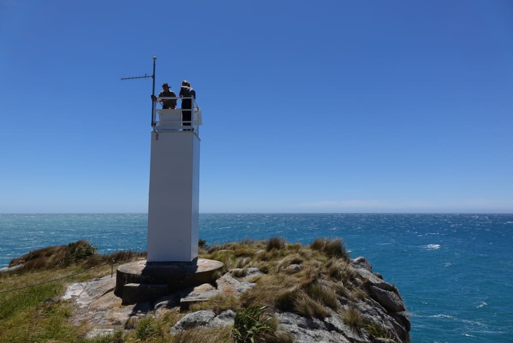 Mike Ogle and Crystal Brindle from DOC checking on the time lapse camera at the top of the lighthouse.