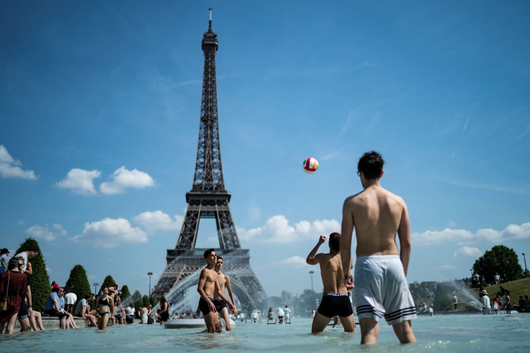 Teenagers play volleyball in the Trocadero fountain as France swelters in a heatwave.