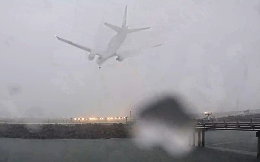 The Air New Zealand flight from Melbourne landing amid heavy rain and low visibility.