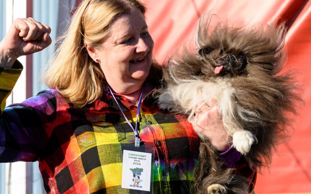 Owner Ann Lewis holds up her dog Wild Thang after winning first prize in the annual World's Ugliest Dog contest at the Sonoma-Marin Fair in Petaluma, California, on June 21, 2024. Wild Thang, a Pekingese dog who had already entered the competition four times, finally won the 34th annual World's Ugliest Dog competition and was awarded $5,000. (Photo by JOSH EDELSON / AFP)