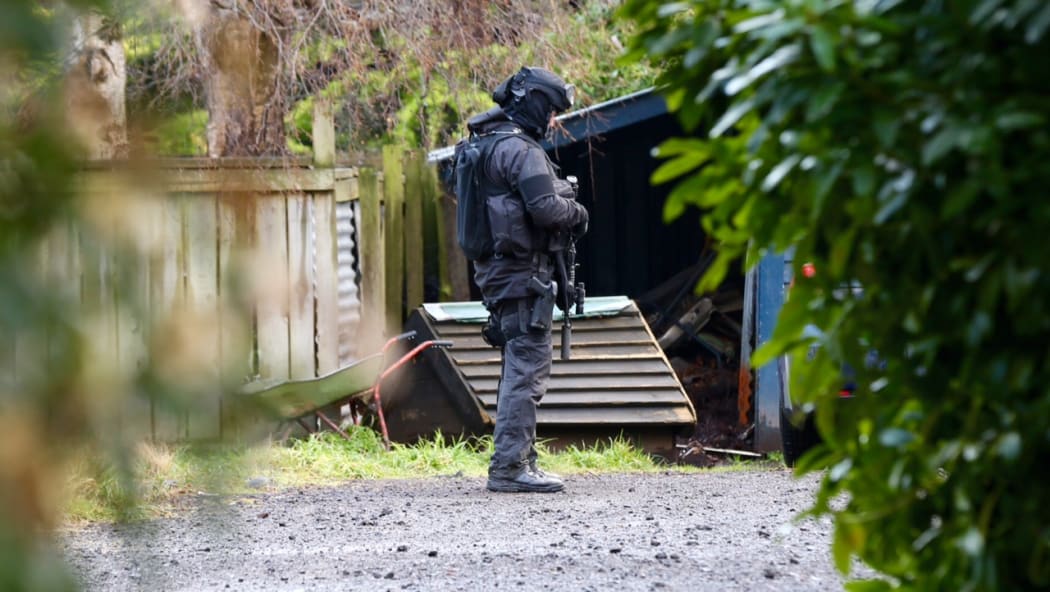 An armed police officer at an address in Ohakune during the search for Dolphy Kohu and his associates.