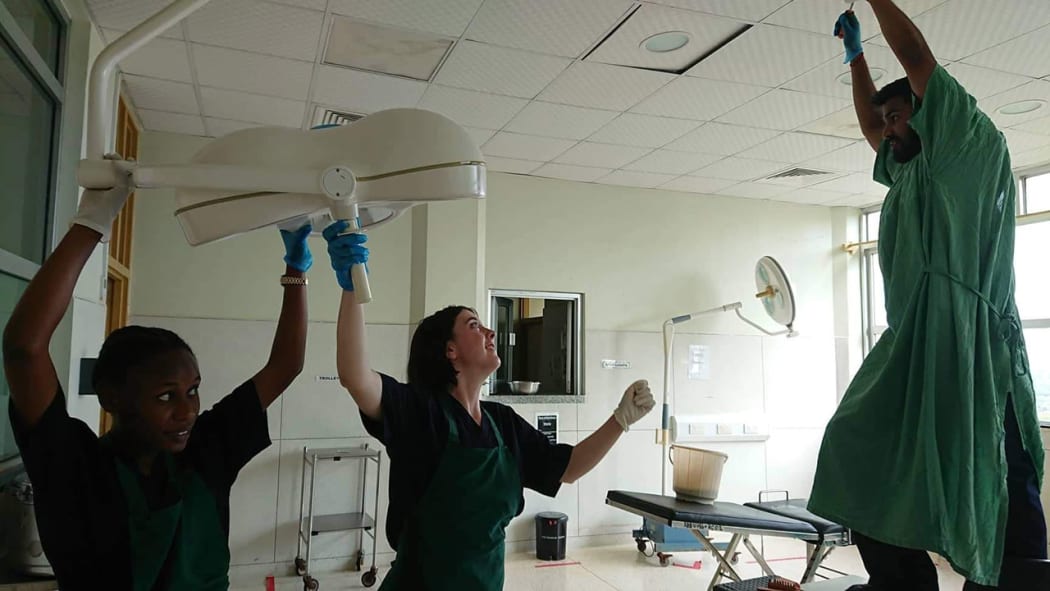 Kiara Miller and fellow interns, triumphant after fixing surgical lights, at Entebbe Hospital, Uganda