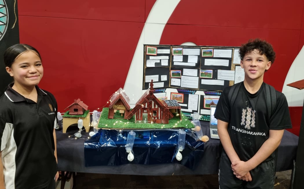 Meremia and Ezra from Te Rangihakahaka Wakanoa and their model of a marae built to rise from floodwaters