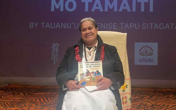 Tusitala (Author) Tauanu'u smiling in joy as he holds his newly published book - Samoan Proverbs for Children.
