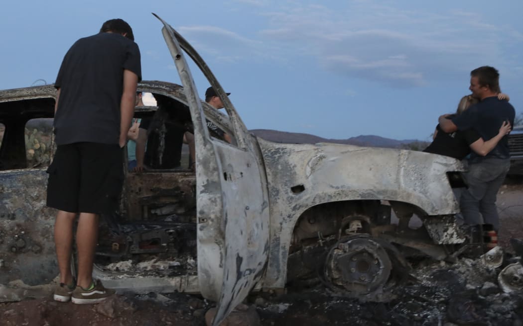 Members of the Lebaron family look at the burned car where part of the nine murdered members of the family were killed and burned during an ambush in Bavispe, Sonora mountains, Mexico, on November 5, 2019.