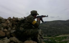 A Free Syrian Army (FSA) member backed by Turkish military at a village in Afrin
