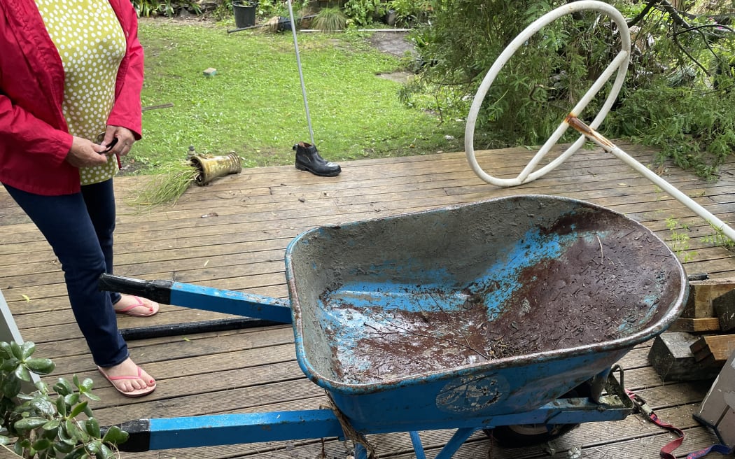 A wheelbarrow that was washed into the garden of Annette Kennedy's West Auckland home by floodwaters on 27 January, 2023.