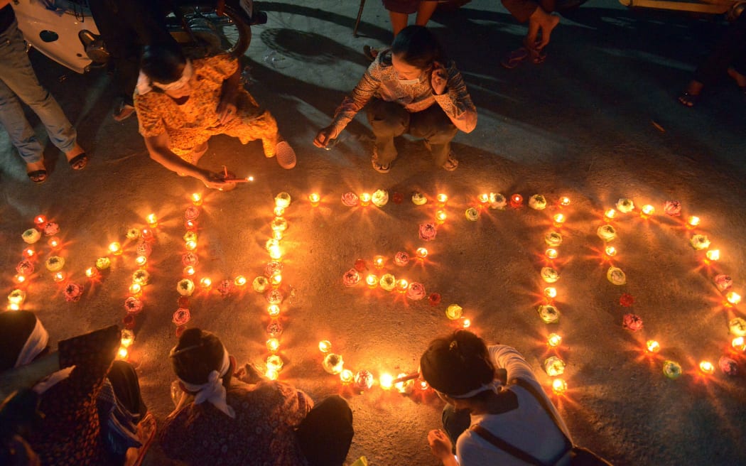 Cambodian residents light candles for the missing Flight MH370 at their village in Phnom Penh.