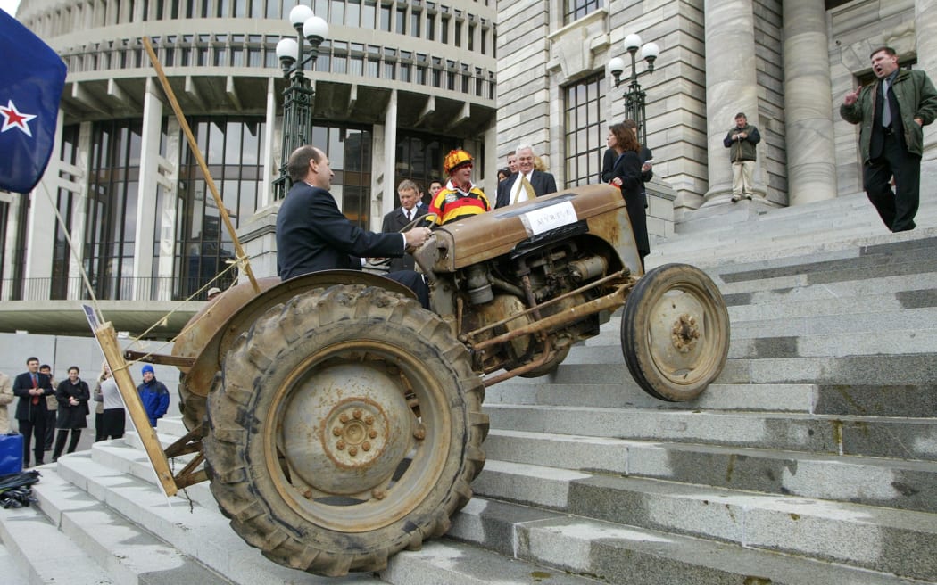 National MP Shane Ardern is ordered to stop by security head Andrew Standish while attempting to drive a tractor up Parliament Steps during the farmers so called anti-fart protest, to demonstrate their opposition to the government's proposed tax to limit methane emissions, Wellington, September 4, 2003.