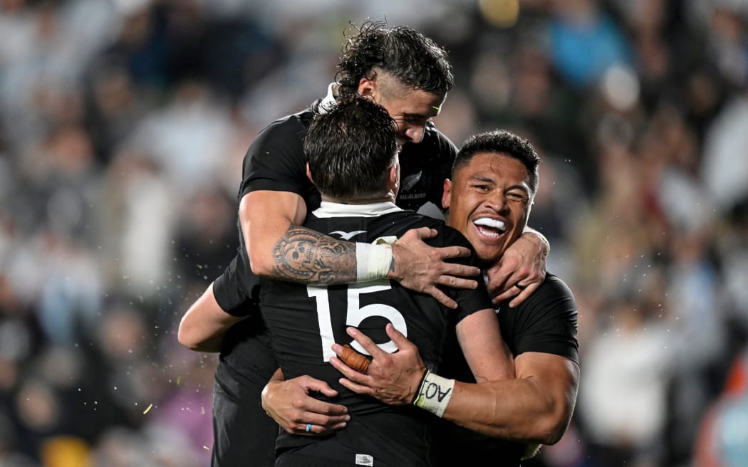 Beauden Barrett of New Zealand celebrates his try with TJ Perenara and Caleb Clarke.