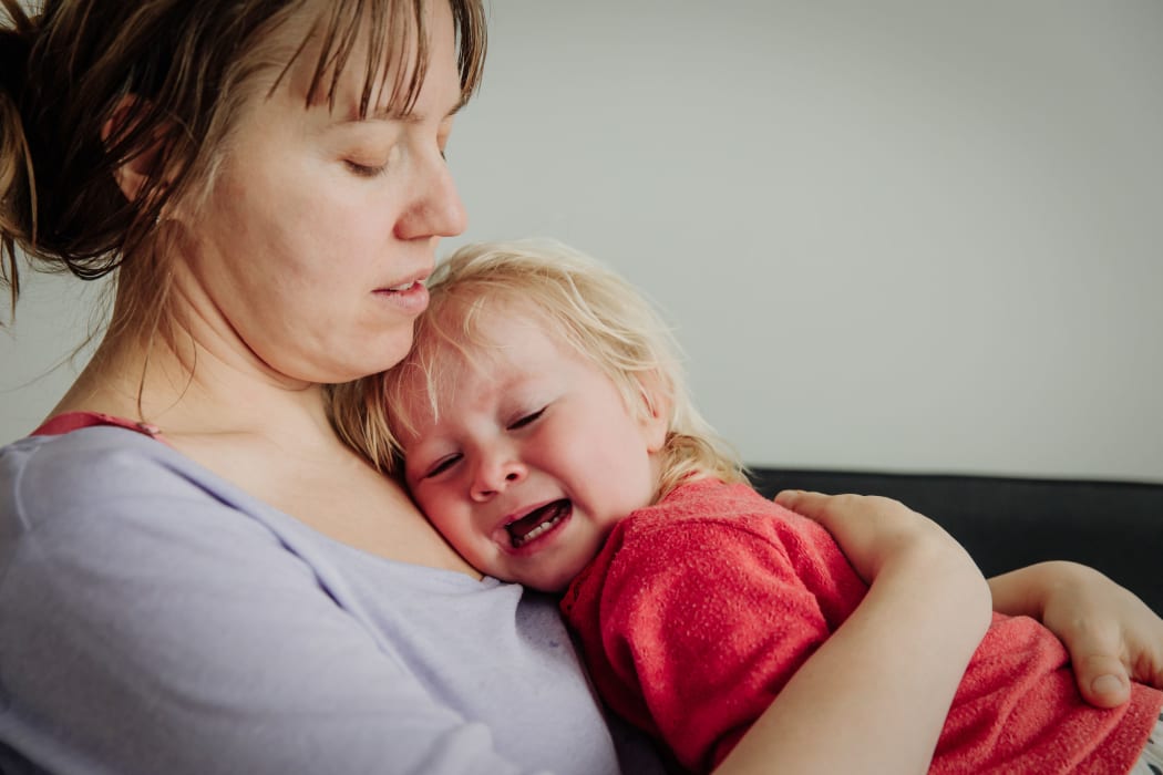 A photo of a mother comforting crying little baby, pain, grief and parenting