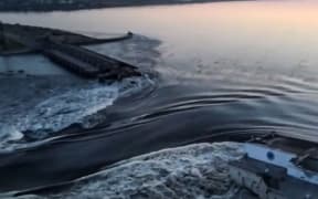 This screen grab from a video posted on Ukraine's President Volodymyr Zelensky's Twitter account on 6 June 2023 shows an aerial view of the dam of the Kakhovka hydroelectric power station after it was partially destroyed.