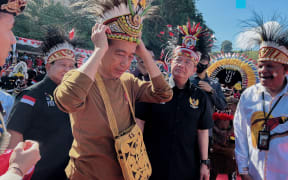 Archive photo taken in March 2023 of Indonesia's President Joko Widodo wearing a traditional Papuan headwear during a visit to the provincial capital Jayapura.