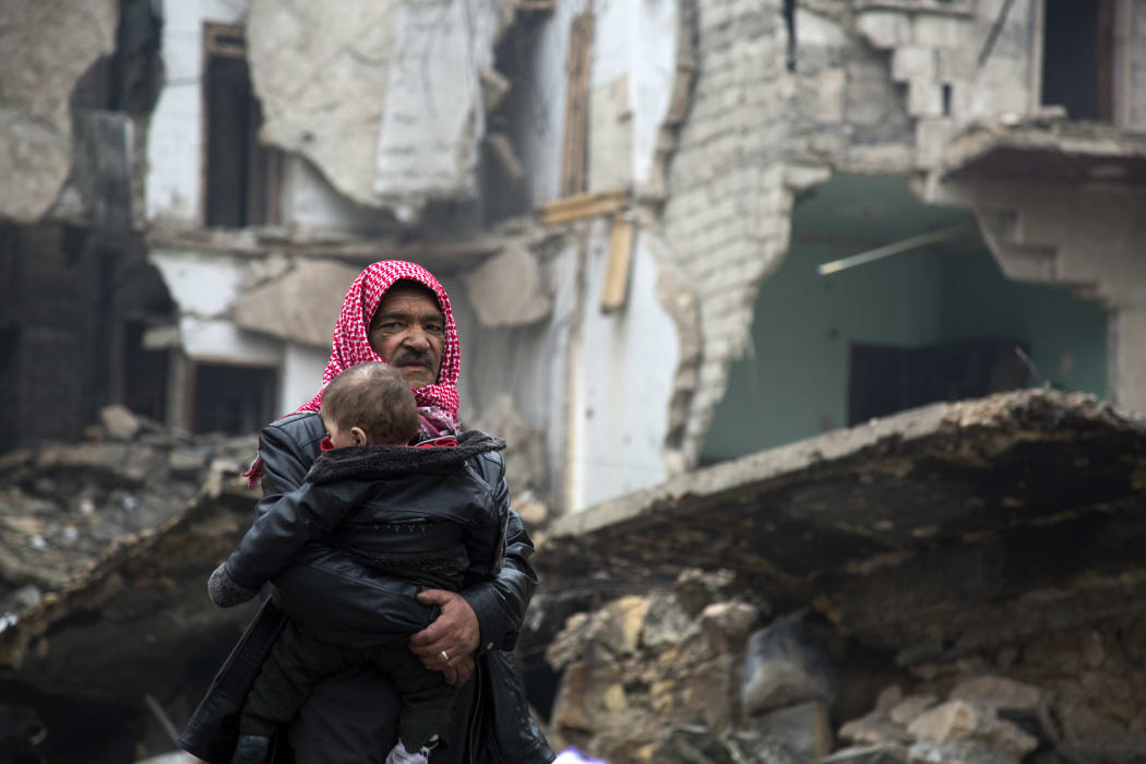 A Syrian man and child leave a rebel-held area of Aleppo.