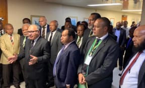 Papua New Guinea prime minister Peter O'Neill (with spectacles) flanked by coalition partners following a parliament session, 7 May 2019.