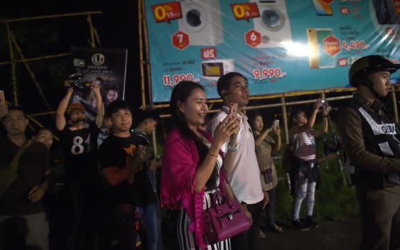 People watch an ambulance understood to be carrying some of the rescued boys leaving the military airport in Chiang Rai to a nearby hospital.