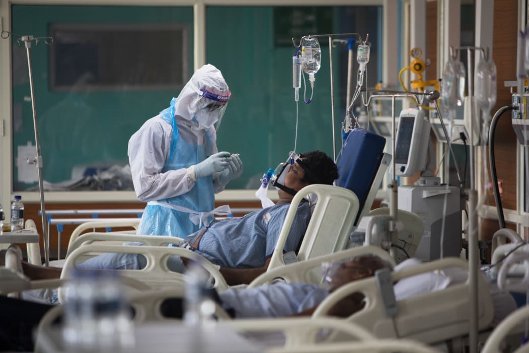 A medical staff member looks after a Covid-19 patient at the Intensive Care Unit of the Sharda Hospital, in Greater Noida in July 2020.