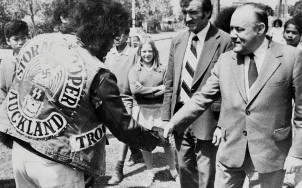 Prime Minister Robert Muldoon shakes hands with a gang member employed on a work scheme, Bairds Road, Otara, November 2 1979.