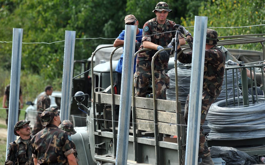 Hungarian soldiers, on the border with Croatia, put up fences a crossing on 22 September 2015.