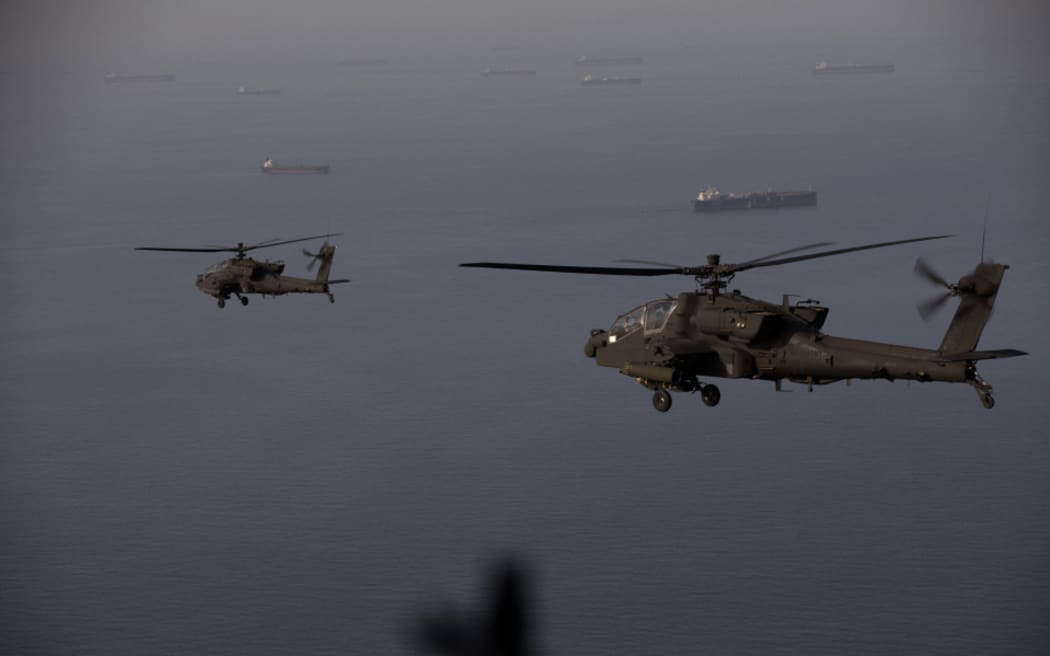 This handout photo released by US Central Command via their X account (@CENTCOM) on April 18, 2026 shows AH-64 Apaches flying above the Strait of Hormuz during a patrol on April 17, 2026. Iran’s military declared the Strait of Hormuz closed again on April 18, prompting ships to abandon attempts to transit and President Donald Trump to warn Tehran against trying to “blackmail” the United States. On April 17, Tehran had declared the strait, which usually carries a fifth of the world’s oil and liquefied natural gas, open after a ceasefire was agreed in Israel’s war with Iran’s ally Hezbollah in Lebanon. (Photo by US Central Command (CENTCOM) / AFP) / RESTRICTED TO EDITORIAL USE - MANDATORY CREDIT “AFP PHOTO /  US CENTRAL COMMAND ” - HANDOUT - NO MARKETING NO ADVERTISING CAMPAIGNS - DISTRIBUTED AS A SERVICE TO CLIENTS