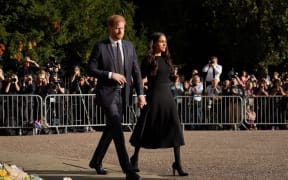 Prince Harry, Duke of Sussex (L) and Meghan, Duchess of Sussex (R) arrive to look at floral tributes on the Long walk at Windsor Castle.