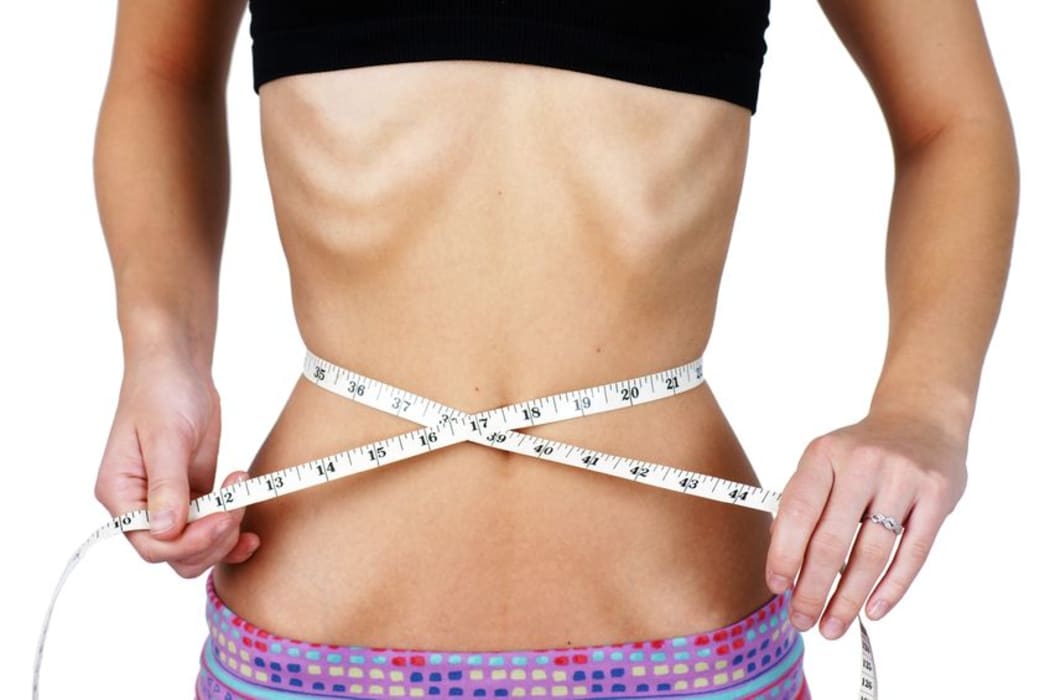 A photo of an anorexic girl measuring her waist