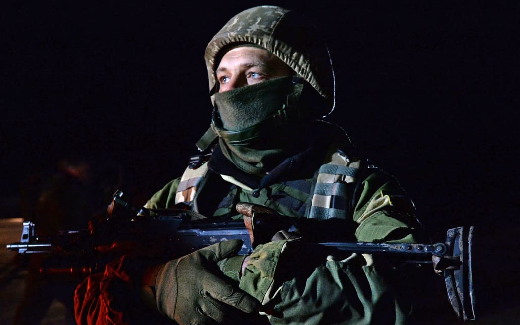 A Ukrainian soldier stands guard during the prisoner exchange.