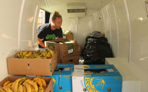 An image of Sam Mentink loading donated food into the Kiwi Harvest van.
