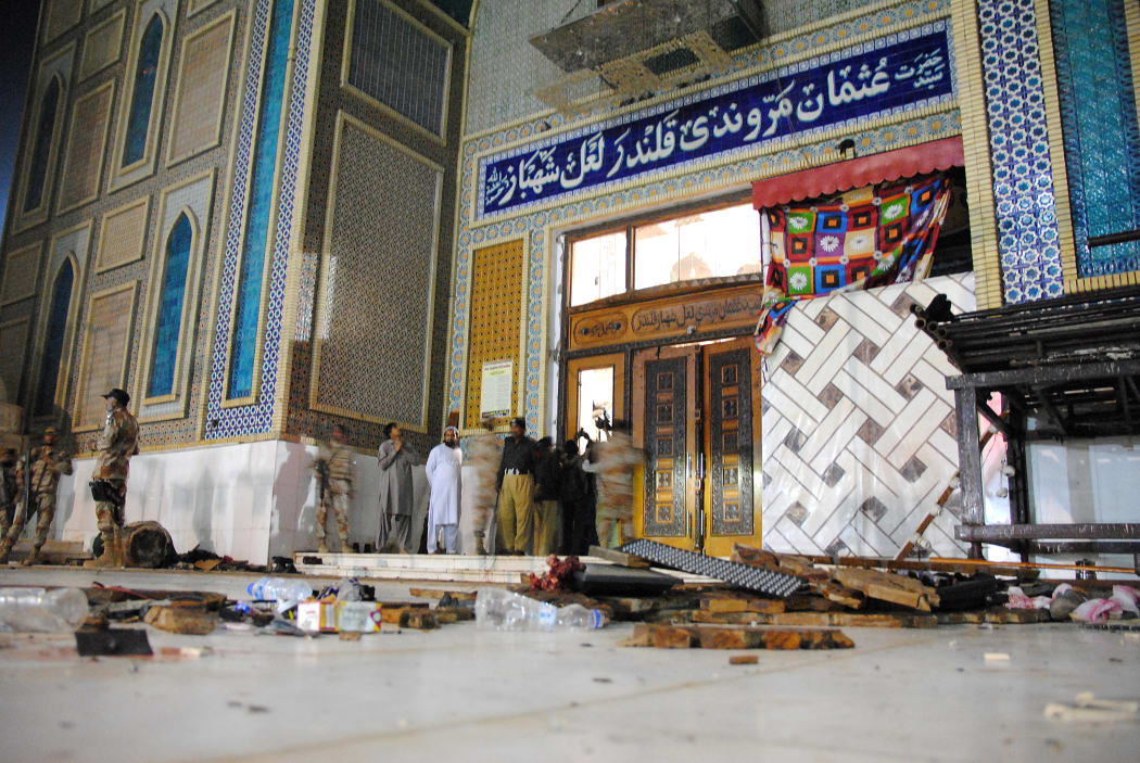 Debris is seen on the ground as Pakistani soldiers cordon off the shrine of 13th century Muslim Sufi Saint Lal Shahbaz Qalandar