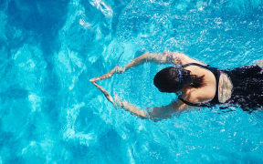 Overhead view of mature woman  swimming in swimming pool (Photo by Matt Lincoln / Cultura Creative / Cultura Creative via AFP)